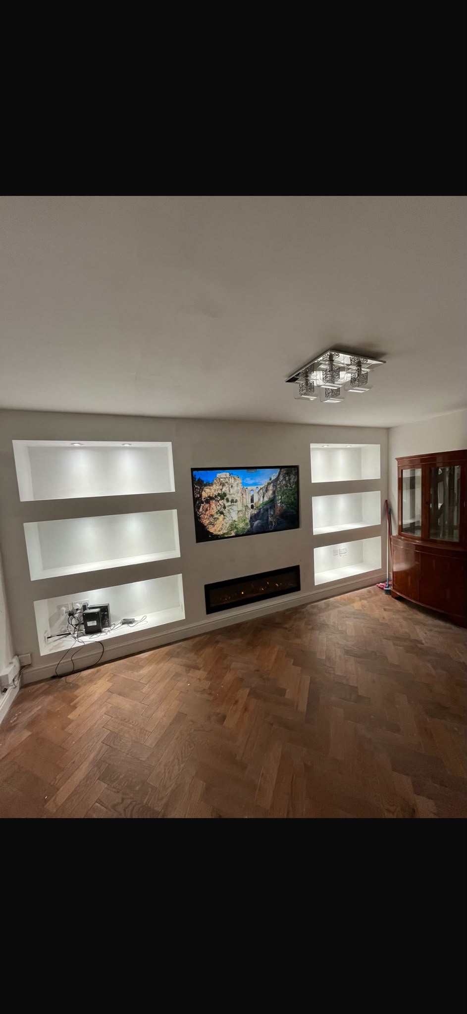 Media wall with television, illuminated shelves and electric fire